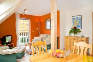 a living room with orange walls and a table at Ferienwohnung Milow in Polchow