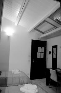 Schlafzimmer mit einem Bett, einem Schreibtisch und einer Tür in der Unterkunft Abraxia B&B in Comiso