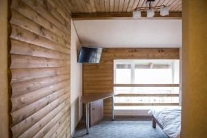 a bedroom with a wooden accent wall and a desk at Hotel & Restaurant Complex HAP-OK in Brodki