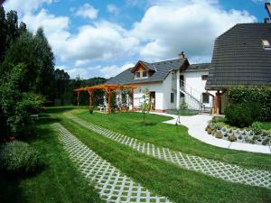 a house with a pathway leading to a yard at Gólya Vendégház in Tiszaug