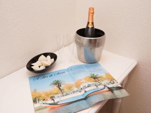 a bottle of wine in a bucket on a book at Peters Guesthouse in Aveiro