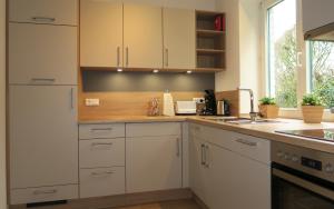 a kitchen with white cabinets and a sink at FeWo Grafschaft in Nordhorn
