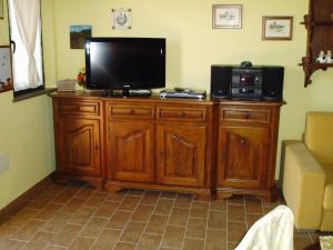 un televisore su un supporto in legno in soggiorno di Agriturismo B&B Le Gazze a Porto San Giorgio
