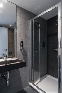 a bathroom with a shower and a sink at Brxxl 5 City Centre Hostel in Brussels