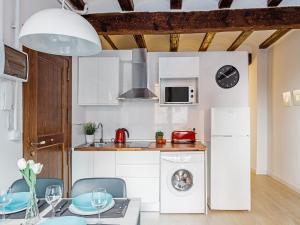 バレンシアにあるUNIK. Apartments Valenciaのキッチン(白い家電製品、テーブル、椅子付)
