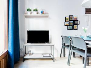 ein Wohnzimmer mit einem TV und 2 Stühlen in der Unterkunft UNIK. Apartments Valencia in Valencia