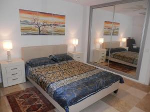 マルベーリャにあるMarbella 2000 Elegant Apartmentのベッドルーム(ベッド1台、大きな鏡付)