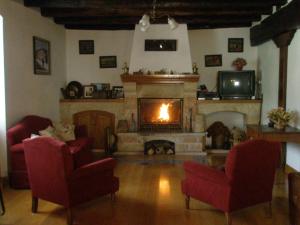 a living room with two chairs and a fireplace at Casa Rural Parriola in Villanueva de Arce