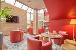 a waiting room with red chairs and a table at Campanile Paris Ouest - Nanterre - La Défense in Nanterre