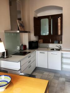 a kitchen with white cabinets and a sink at 19th Century Sevillian Apartment in Seville +5 photos