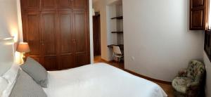 a bedroom with a bed and a chair and a desk at 19th Century Sevillian Apartment in Seville
