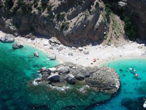 an aerial view of a beach with people in the water at Cala Gonone Cozy House Sea View in Cala Gonone