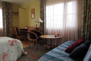 a hotel room with a bed and a table and a desk at Arina Holiday House in Nasva