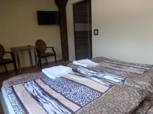 two beds in a room with chairs and a table at Zajazd Sielankowe Klimaty in Kokotek