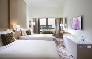 Postel nebo postele na pokoji v ubytování Metropolitan Hotel Dubai