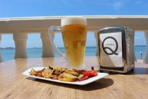 un plato de comida y una taza de cerveza en Apartamentos Dominique, en La Manga del Mar Menor