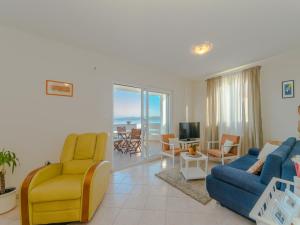 a living room with a blue couch and yellow chairs at Holiday house Mareta, Sea View in Dragove