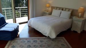 a bedroom with a white bed and a window at Casa Douro Terrace in Baião