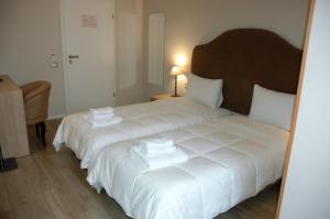 A bed or beds in a room at Hotel Hermes Tirana