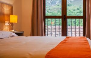 ラス・アレーナス・デ・カブラレスにあるApartamentos El Caxiguのベッドルーム1室(ベッド1台、大きな窓付)