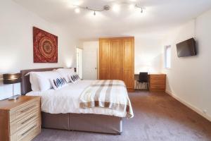 a bedroom with a large bed and a television at ShortstayMK Northleigh House spacious home 6 bedrooms 5 bathrooms BT sports and Sky in Milton Keynes