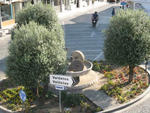 a person riding a scooter down a street with a fountain at Apartments Circle Olive in Ulcinj +15 photos