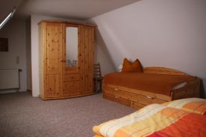 1 dormitorio con 1 cama y armario de madera en Ferienwohnung Gliese, en Beeskow