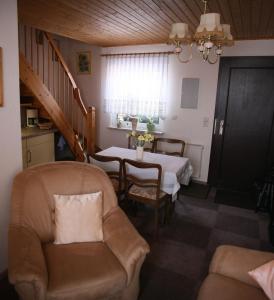 ein Wohnzimmer mit einem Tisch, Stühlen und einer Treppe in der Unterkunft Ferienwohnung Gliese in Beeskow