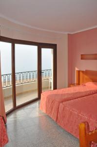 1 dormitorio con cama y vistas al océano en Hotel Haromar, en Calella