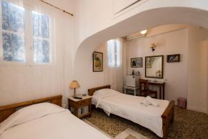 two beds in a room with an archway at Hotel Delphines in Mýkonos City