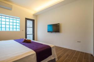 ein Schlafzimmer mit einem Teddybär, der auf einem Bett sitzt in der Unterkunft I Stay B&B in Hualien