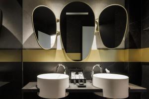 a bathroom with two sinks and a mirror at Marquis Hotels Issabel's in Granada