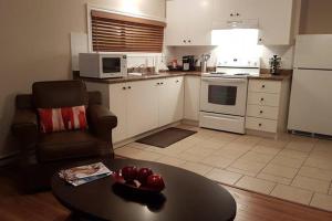 a living room with a table and a kitchen at 1-Bedroom Apartment Sweet #7 by Amazing Property Rentals in Gatineau