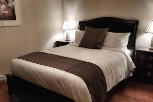 a bedroom with a large bed with two night stands at Two-Bedroom Apartment Sweet #4 by Amazing Property Rentals in Gatineau