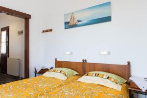 1 dormitorio con 2 camas y un velero en la pared en Pension Afroditi, en Apollonia