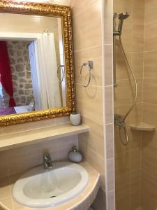 a bathroom with a sink and a mirror and a shower at Villa Sigurata II in Dubrovnik