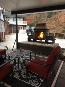 a fireplace on a patio with a chair and a table at Grafton Lodge in Lake Lure