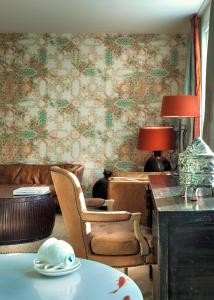 a living room with a table and chairs and wallpaper at Little Grand in Eindhoven