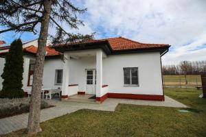 une maison blanche avec un toit rouge dans l'établissement Gyevitur Apartman, à Algyő