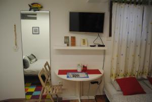Habitación con mesa y TV en la pared. en optimist split, en Split