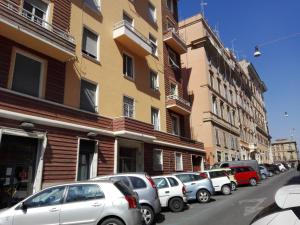 una fila de autos estacionados en una calle al lado de edificios en Il Mattoncino - Colosseo, en Roma