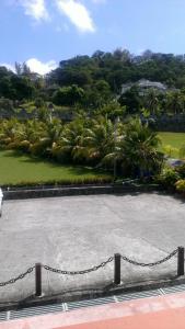 a chain in front of a parking lot with palm trees at Paradise Beach Hotel in Kingstown