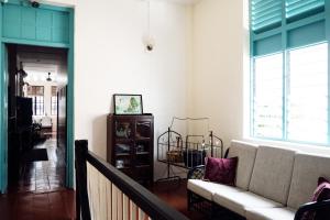 a living room with a couch and a window at Sojourn Beds & Cafe in Taiping