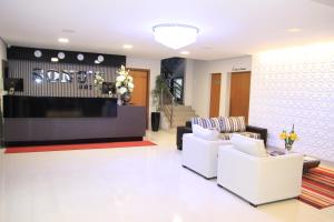 a lobby with two white chairs and a counter at Sonus Hotel in Sinop