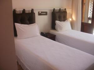 a hotel room with two beds and two lamps at Hotel Pousada Encanto de Itapoan in Salvador