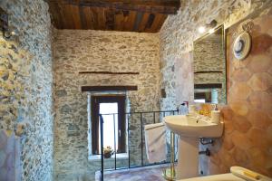 a stone bathroom with a sink and a mirror at Residenza d'Epoca Borgodifiume in Fiumefreddo Bruzio