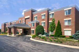 un gran edificio de ladrillo rojo con aparcamiento en Extended Stay America Select Suites - Chicago - Westmont - Oak Brook, en Westmont