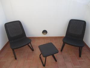 two chairs sitting on a floor next to a wall at Casa do vale das Hortas in Balurco de Baixo