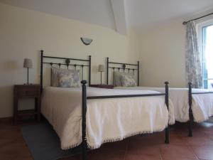 Balurco de BaixoにあるCasa do vale das Hortasのベッドルーム(白いシーツを使用した大型ベッド1台付)