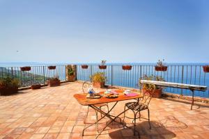 a table and chairs on a patio overlooking the ocean at Residenza d'Epoca Borgodifiume in Fiumefreddo Bruzio